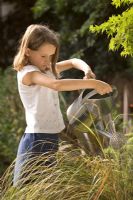 Girl watering plants with watering can