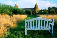 Blue bench at the end mown grass path
Oast Houses in Hampshire