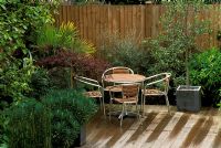 Modern furniture on decking with tropical planting and containers in Streatham, London