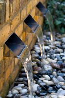 Water feature with three rills and pebbles