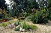 Dry gravel garden beach stones and stone bench at Heathfield in Surrey