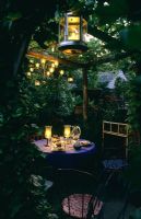 Lighting at outdoor eating area under pergola in garden at Park Terrace in Sussex