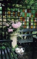 Secluded seating area with trellis fencing and stained glass panes 