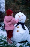 Child making snowman at Gowan Cottage in Suffolk 