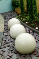 Row of three spherical water features in contemporary garden at Capel Manor Show Gardens