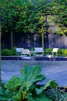 Cartier garden at Chelsea 2000, furniture on patio edged with structural green planting