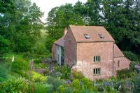 View of house set in informal country garden at The Old Cornmill, Herefordshire 