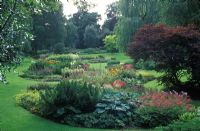 View of the Dell Garden 2000, showing island beds with mixed herbaceous perennials and mature trees