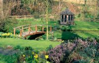 Garden with small wooden footbridge over stream
