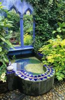 Small town garden with blue mosaic water feature 