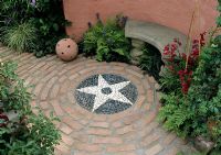 Courtyard garden - Brick circle with black and white cobble stone circle. 
