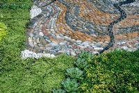 Decorative pebble paving edged with Sempervivum tectorum, Thymus citriodorus, Thymus 'Doone Valley' and Saxifraga moschata 'Cloth of Gold'.