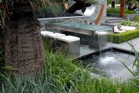 Outdoor seating area with a table water fountain and pool