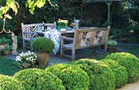 Wooden furniture on patio with topiary 