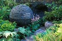Drystone slate sphere and wall recess sculpture - Euphorbia, Rheum, Ferns, Persicaria - 'The Philosopher's Garden' at RHS Chelsea FS