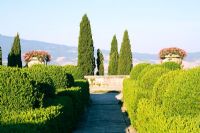 Large Tuscan garden with clipped boxed topiary hedging and view accross the countryside, Villa La Foce, Italy