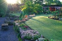 View of The Walled Garden, Holehird Gardens, Windermere, Cumbria in early morning with rays of sunlight and dew on grass