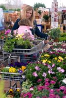 Family at plant centre with trolly loaded with plants, selecting plants
