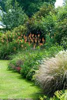 The Long borders with Kniphofia, ornamental grasses, Hosta and shrubs. 27 June. Lucy Redman's School of Garden Design, Rushbrook, Nr. Bury St. Edmunds, Suffolk. 