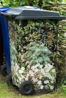 Dustbin covered in paper with a picture of flowers to disguise or camoflage the plastic bin. Lucy Redman's School of Garden Design, Rushbrook, Nr. Bury St. Edmunds, Suffolk. 