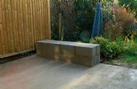 Before constructing a new patio in urban garden - Concrete laid and breeze block bench partly constructed - Garden beyond with Euonymus, Solanum jasminoides, Rosa 'Parade' and Miscanthus sinensis - Elmsdale Road, London