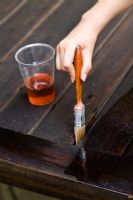 Treating wooden table with oil to protect it