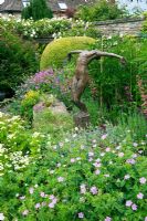Bronze statue of woman in informally planted summer bed - Hillesley House, Gloucestershire