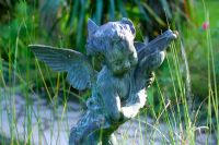 'Winged fairy' statue in pond area at Heligan Garden, Cornwall  