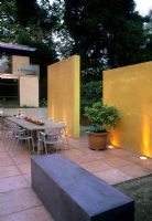Contemporary patio with yellow wall lit by uplighters - Kuhling, USA