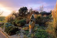 Dry garden in winter with sculpture in gravel border - Hyde Hall, Essex