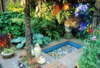 Mediterranean style courtyard garden with raised pool and blue painted wall - Brighton