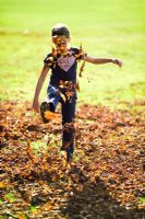 Girl playing with Autumn leaves