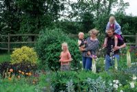 Family walking through garden borders - Pannells Ash farm West, Suffolk 