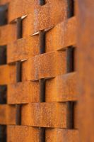 A lattice fence of rusted oxidised steel