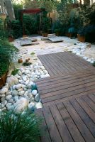 Roof garden with red cedar decking, bamboo loungers, white boulders and barleycorn gravel