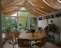 View from inside conservatory with shade blinds to garden, Design Lisette Pleasance