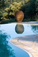 View across swimming pool towards terracotta urn in Gina Price's Corfu garden
