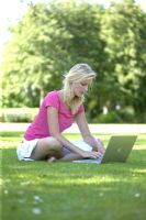 Young woman on lawn with laptop