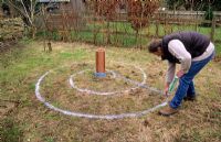 Marking out spiral on ground with marking paint - to plant bulbs by