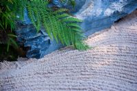 Japanese minimalist garden with sand, rocks and fern