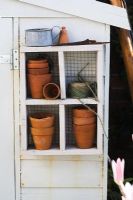 Improvised shelves adding interest and usefulness to exterior of garden shed