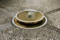 Circular fountain in cobbled courtyard of the Generalife Gardens - Gardens of the Alhambra, Granada, Spain 