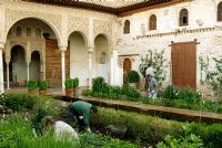 Gardeners working in the Patio de la Acequia Water Garden of the Generalife Gardens - Gardens of the Alhambra, Granada, Spain