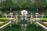 Fountain in large wooded garden in eary spring - The Italian garden, Compton Acres, Dorset 