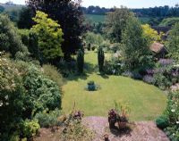 View of garden with Taxus baccata 'Fastigiata' and two circular lawns. 