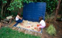 Two girls playing in a sandpit 