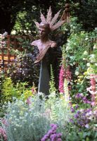 Bronze head and shoulder 'Helios' sculpture in flowerbed - Godstone gardners club, Chelsea 2000