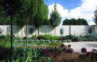 Contemporary minimal garden with patio sculpture clipped hornbeams and perennial planting - Chelsea 2002 