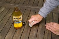 Oiling a garden table with linseed oil