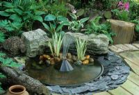 Small pre-formed pond in decking with built in fountain.  